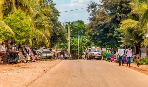 African road through village people going about business