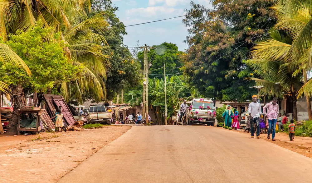 African road through village people going about business