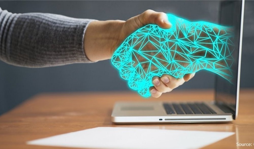 digital hand reaching from computer to shake user's hand