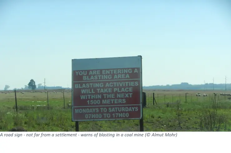 A road sign - not far from a settlement - warns of blasting in a coal mine 