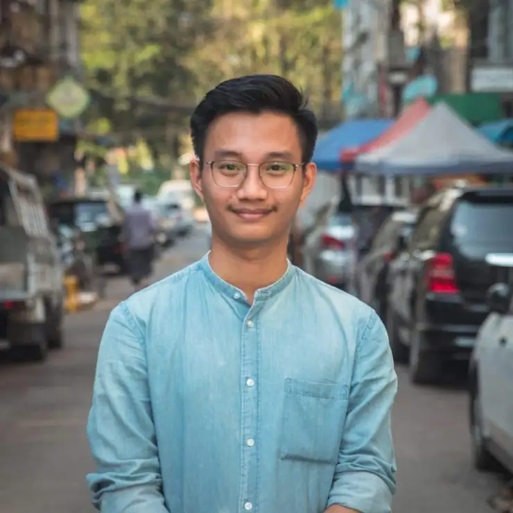 A man in blue shirt wearing glasses