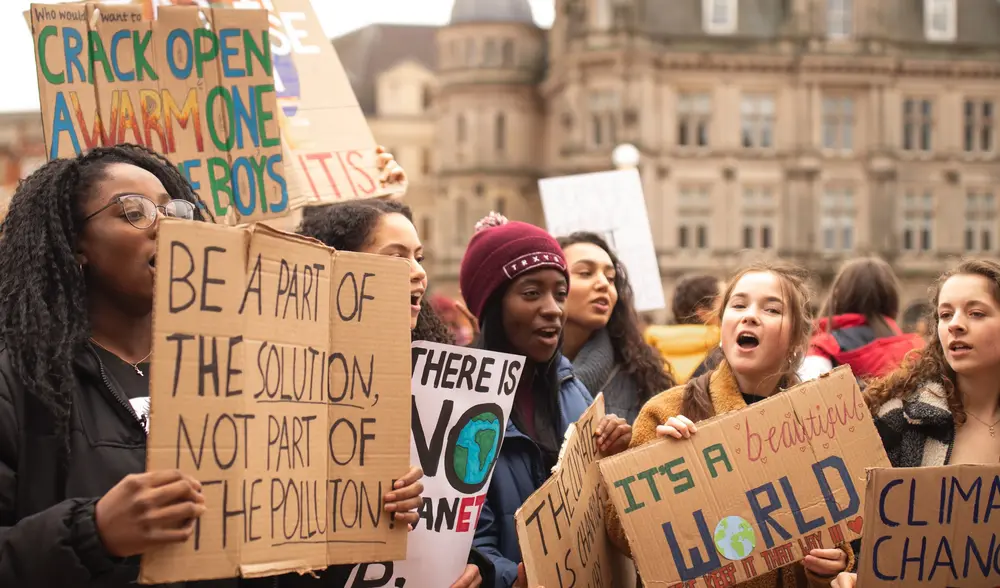 Teenagers carrying posters with messages related to climate change